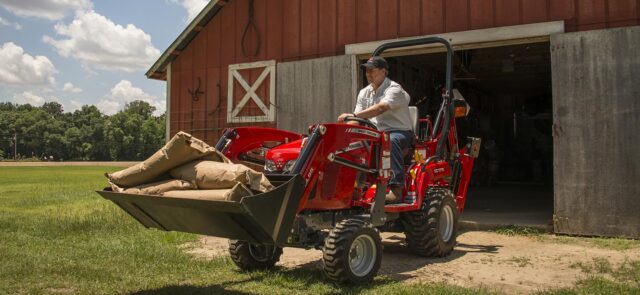 Massey Ferguson Utility Tractor moving large bags with front-end loader